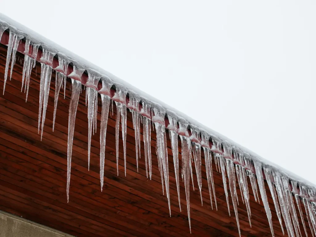 icicles are formed on the edge of a wooden roof